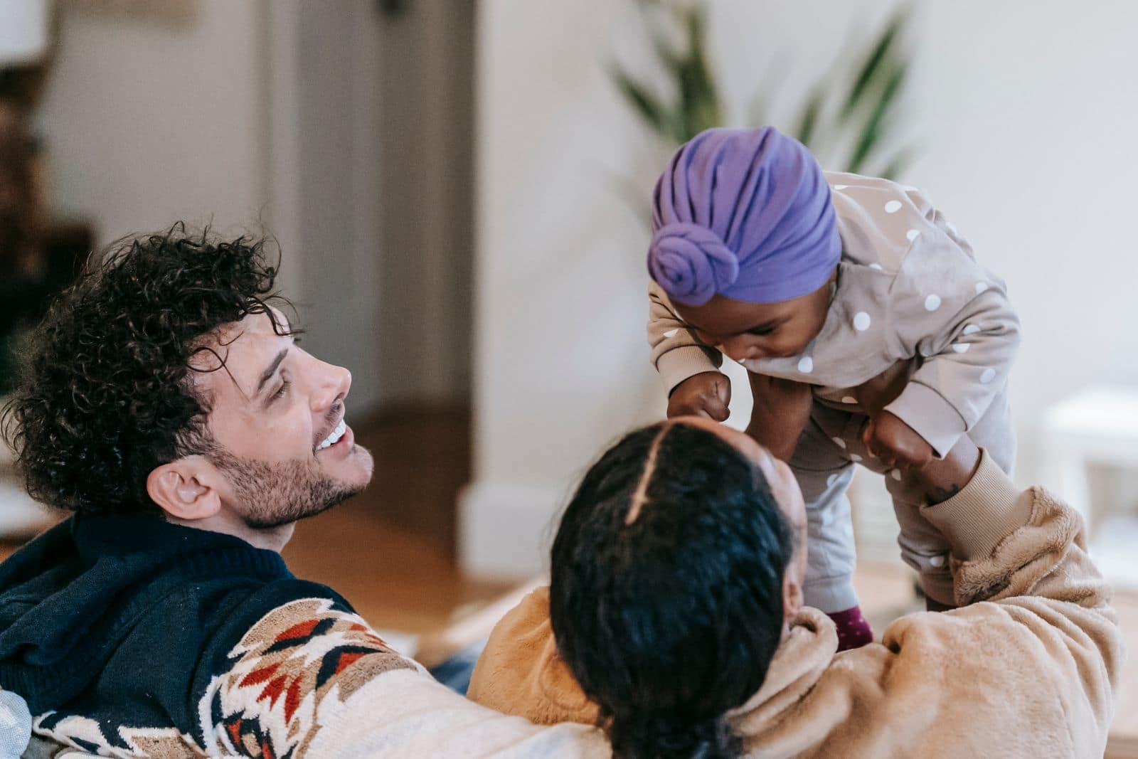 Foster carers playing with a baby in a transracial family placement